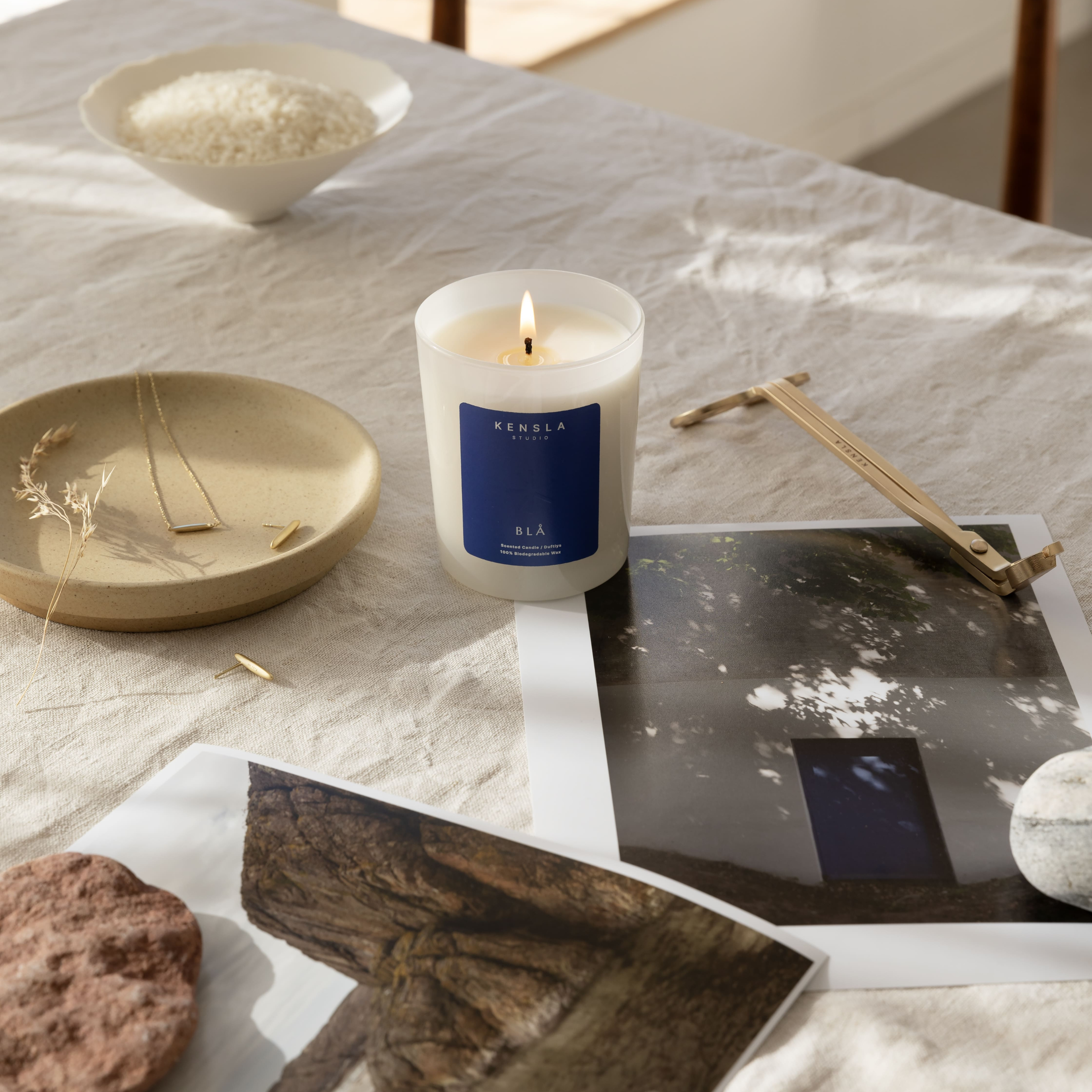 Kensla Candle with a blue label on a marble surface with decorative items